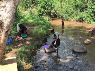 Women_washing_their_clothes_at_Kibogoizi_where_they_get_their_water_to_drink