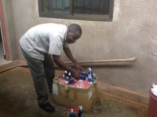 Father Vitalis preparing a box of sanitisers for Rugu School
